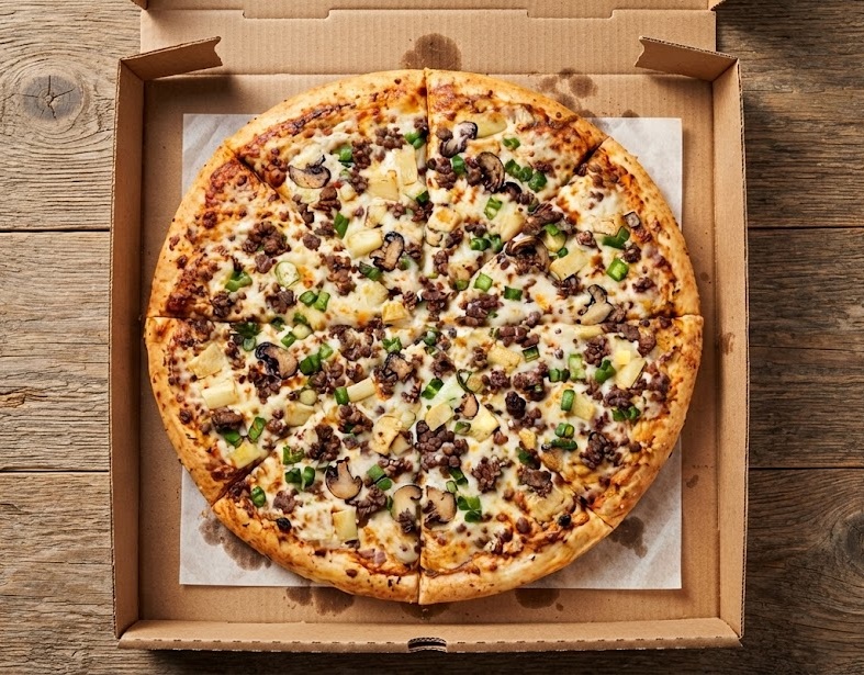 Specialty thick-crust pizza with garlic sauce drizzle, red onion and tomato at Ringers Original Pizza Saskatoon